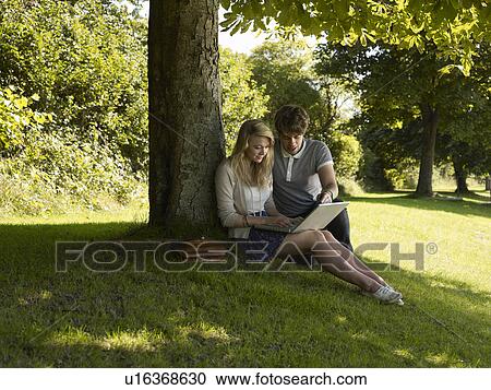 Stock Image - Boy helping a girl in the park. Fotosearch