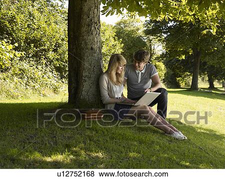Boy helping a girl under a tree View Large Photo Image Stock Photo - Boy helping a girl under a tree. Fotosearch