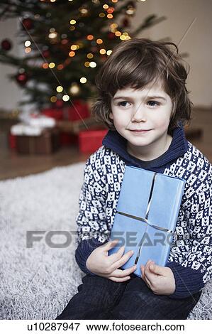 Boy holding gift View Large Photo Image Stock Photo - Boy holding gift. Fotosearch