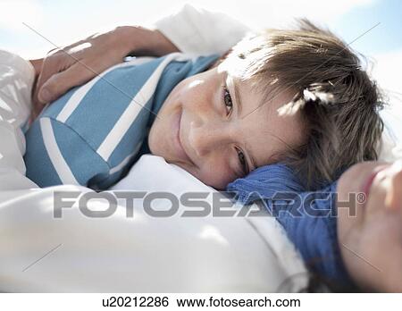 Boy hugging woman, lying down View Large Photo Image Stock Photograph - Boy hugging woman, lying down. Fotosearch