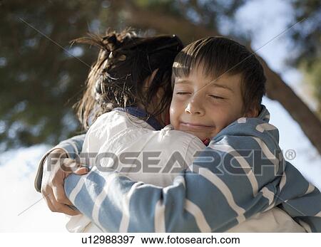 Boy hugging woman, smiling View Large Photo Image Stock Photo - Boy hugging woman, smiling. Fotosearch