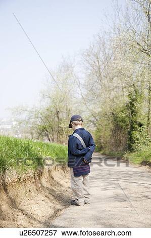 Boy in cap on dirt road View Large Photo Image Stock Photo - Boy in cap on dirt road. Fotosearch