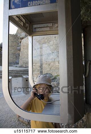Stock Photo - Boy in phone box, on telephone. Fotosearch