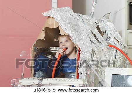 Stock Photography - Boy in self constructed house, smiling. Fotosearch