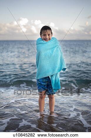 Boy in towel, standing in sea View Large Photo Image Stock Image - Boy in towel, standing in sea. Fotosearch