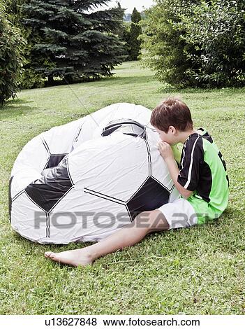 Boy inflating giant football View Large Photo Image Stock Photo - Boy inflating giant football. Fotosearch