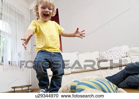 Boy jumping in living room View Large Photo Image Stock Image - Boy jumping in living room. Fotosearch