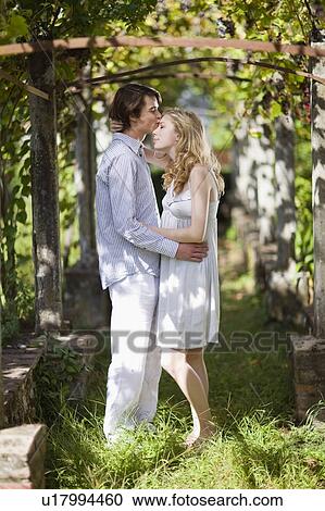 Boy kisses girl in the garden View Large Photo Image Stock Image - Boy kisses girl in the garden. Fotosearch