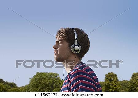 Stock Image - Boy listening to headphones. Fotosearch