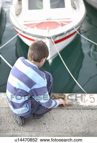 Boy looking at boats in harbour View Large Photo Image Stock Image - Boy looking at boats in harbour. Fotosearch