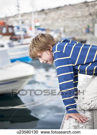Boy looking at water in harbour View Large Photo Image Stock Image - Boy looking at water in harbour. Fotosearch