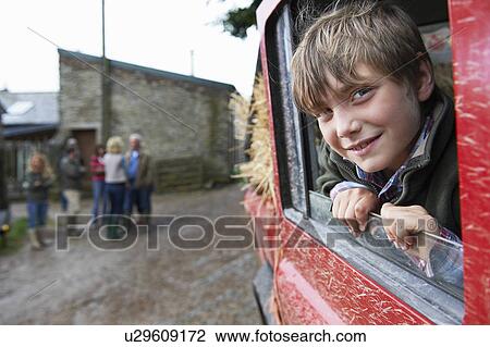 Stock Image - Boy looking out of 4x4 landrover window. Fotosearch