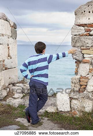 Boy looking out to sea, rear view View Large Photo Image Stock Photography - Boy looking out to sea, rear view. Fotosearch