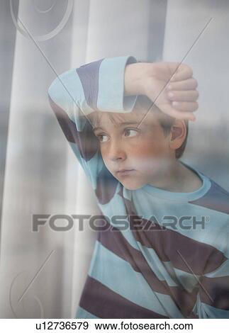 Boy looking through glass of window View Large Photo Image Stock Photo - Boy looking through glass of window. Fotosearch