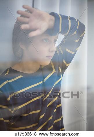 Boy looking through glass of window View Large Photo Image Stock Photo - Boy looking through glass of window. Fotosearch