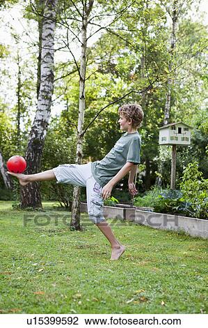 Boy playing with ball in the garden View Large Photo Image Stock Image - Boy playing with ball in the garden. Fotosearch