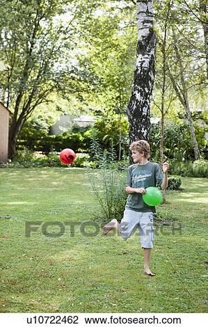 Boy playing with two balls in garden View Large Photo Image Stock Image - Boy playing with two balls in garden. Fotosearch