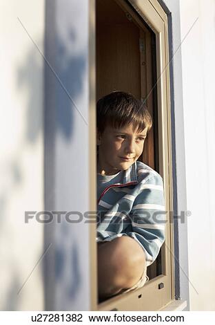 Boy sitting in window View Large Photo Image Stock Image - Boy sitting in window. Fotosearch