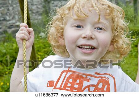 Boy smiling on swing View Large Photo Image Stock Photo - Boy smiling on swing. Fotosearch