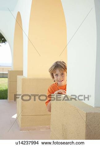 Picture - Boy standing by wall. Fotosearch