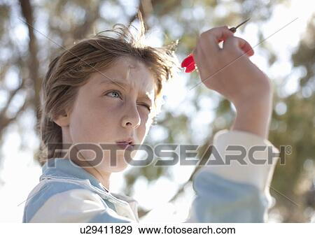 Boy taking aim with dart View Large Photo Image Stock Photo - Boy taking aim with dart. Fotosearch
