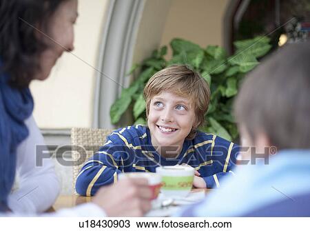 Boy talking to woman at cafe table View Large Photo Image Stock Image - Boy talking to woman at cafe table. Fotosearch