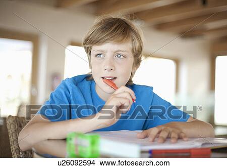Boy working, holding pen View Large Photo Image Picture - Boy working, holding pen. Fotosearch