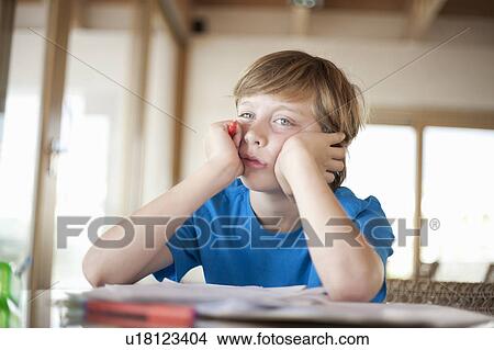 Picture - Boy working, looking bored. Fotosearch