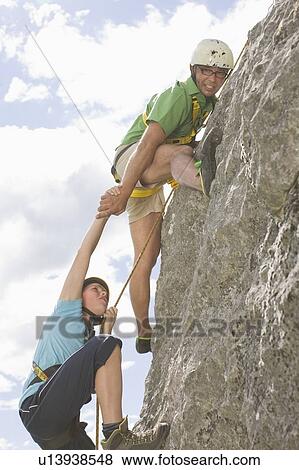 Stock Photo - Boys climbing a rock. Fotosearch