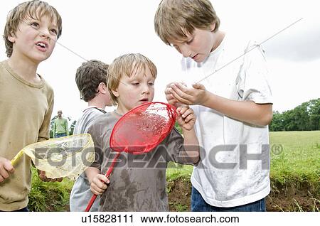 Stock Image - Boys fishing and catching a fish. Fotosearch