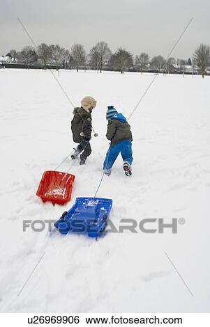 Boys running in snow with sledges View Large Photo Image Stock Photograph - Boys running in snow with sledges. Fotosearch