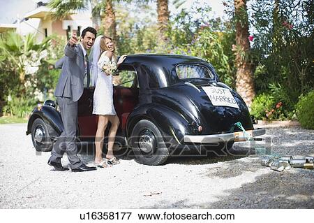 Stock Photo - Bridal couple in front of car. Fotosearch