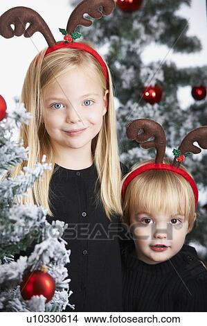 Picture - Brother and sister by the christmas tree. Fotosearch