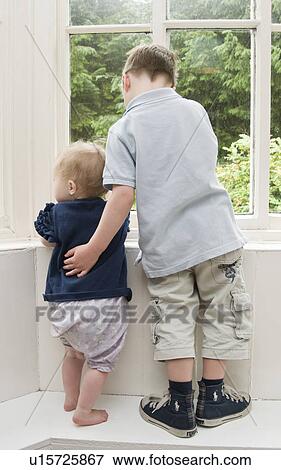 Stock Photo - Brother supporting baby sister. Fotosearch