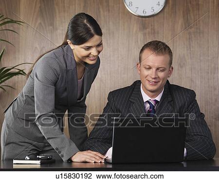 Stock Image - Business man and woman working in office. Fotosearch