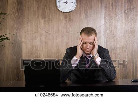Business man head in hands at his desk View Large Photo Image Picture - Business man head in hands at his desk. Fotosearch