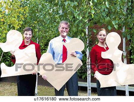 Business team hold jigsaw pieces View Large Photo Image Stock Image - Business team hold jigsaw pieces. Fotosearch