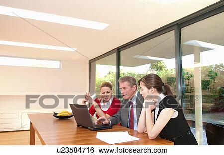 Business team look at computer View Large Photo Image Stock Photograph - Business team look at computer. Fotosearch