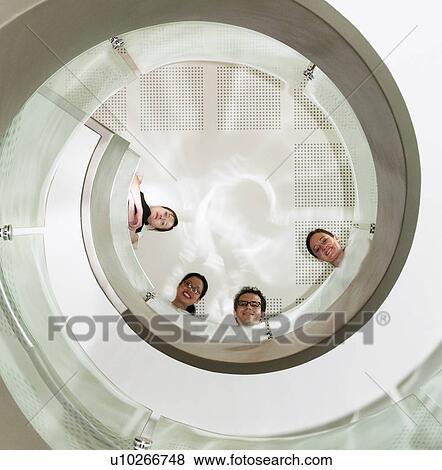 Stock Photo - Business team look down stair well. Fotosearch