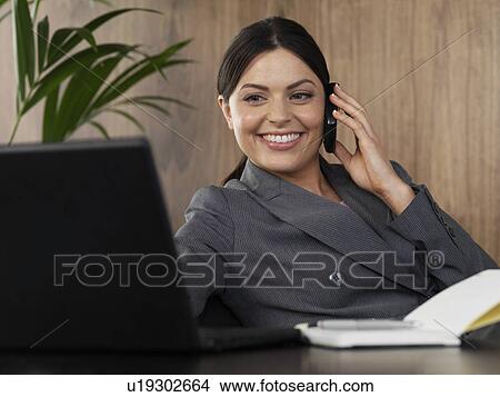Business woman on the phone in office View Large Photo Image Picture - Business woman on the phone in office. Fotosearch