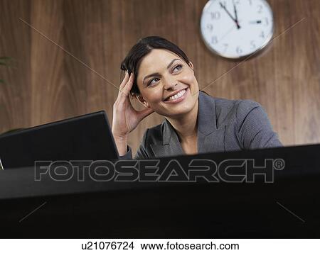Picture - Business woman working at her desk. Fotosearch