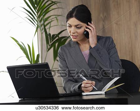 Stock Photograph - Business woman working in office. Fotosearch