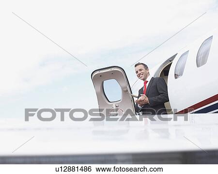 Businessman exiting corporate jet View Large Photo Image Stock Photograph - Businessman exiting corporate jet. Fotosearch