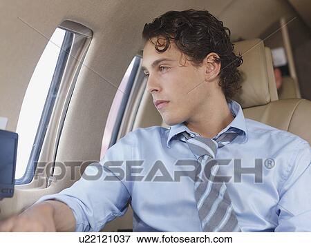 Businessman in corporate jet View Large Photo Image Stock Photo - Businessman in corporate jet. Fotosearch