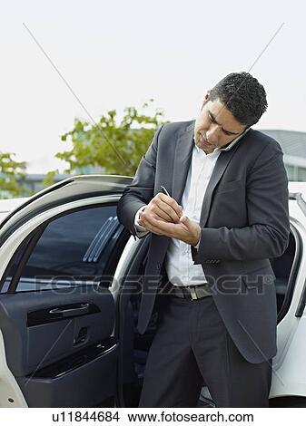 Picture - Businessman taking notes on hand. Fotosearch