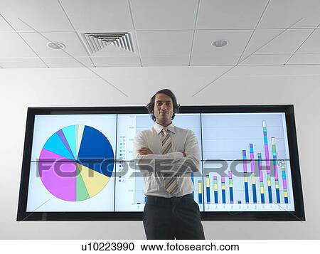 Stock Image - Businessman with graph on screen. Fotosearch