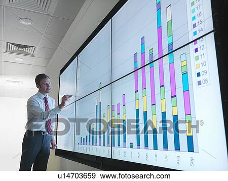 Stock Photo - Businessman with graphs on screen. Fotosearch