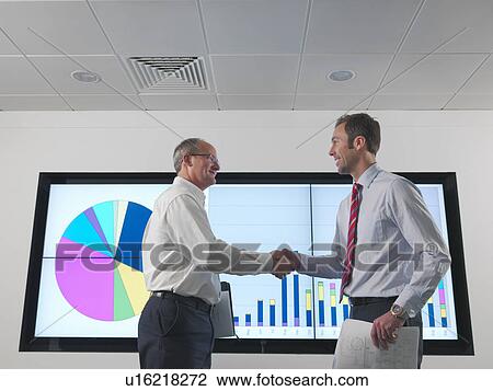 Businessmen shake hands with screen View Large Photo Image Stock Image - Businessmen shake hands with screen. Fotosearch