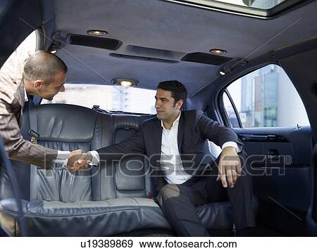 Businessmen shaking hands in limousine View Large Photo Image Stock Photo - Businessmen shaking hands in limousine. Fotosearch