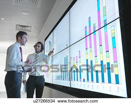 Businessmen with graphs on screen View Large Photo Image Picture - Businessmen with graphs on screen. Fotosearch